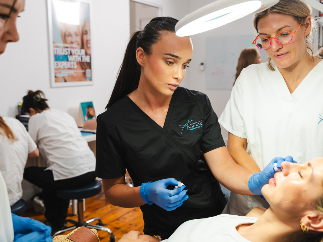 Students learning cosmetic nursing hands on with AACDS trainer