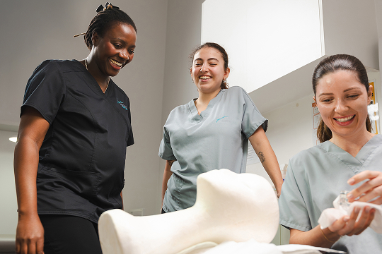 Trainer and students practising facial treatment